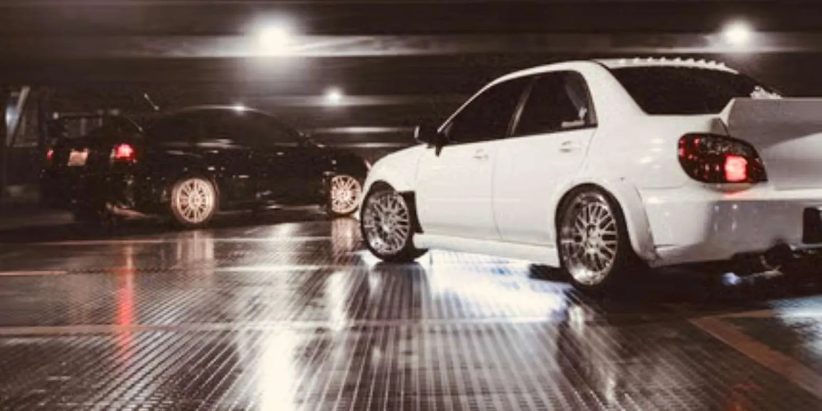 Modified Subaru Impreza WRX parked in a Tokyo parking garage at night