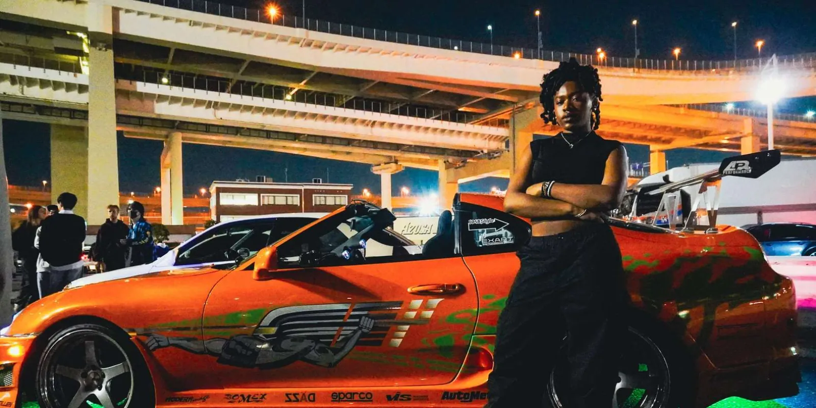 Fast & Furious tribute Mazda RX-8 with a guest posing beside its graffiti-style wrap