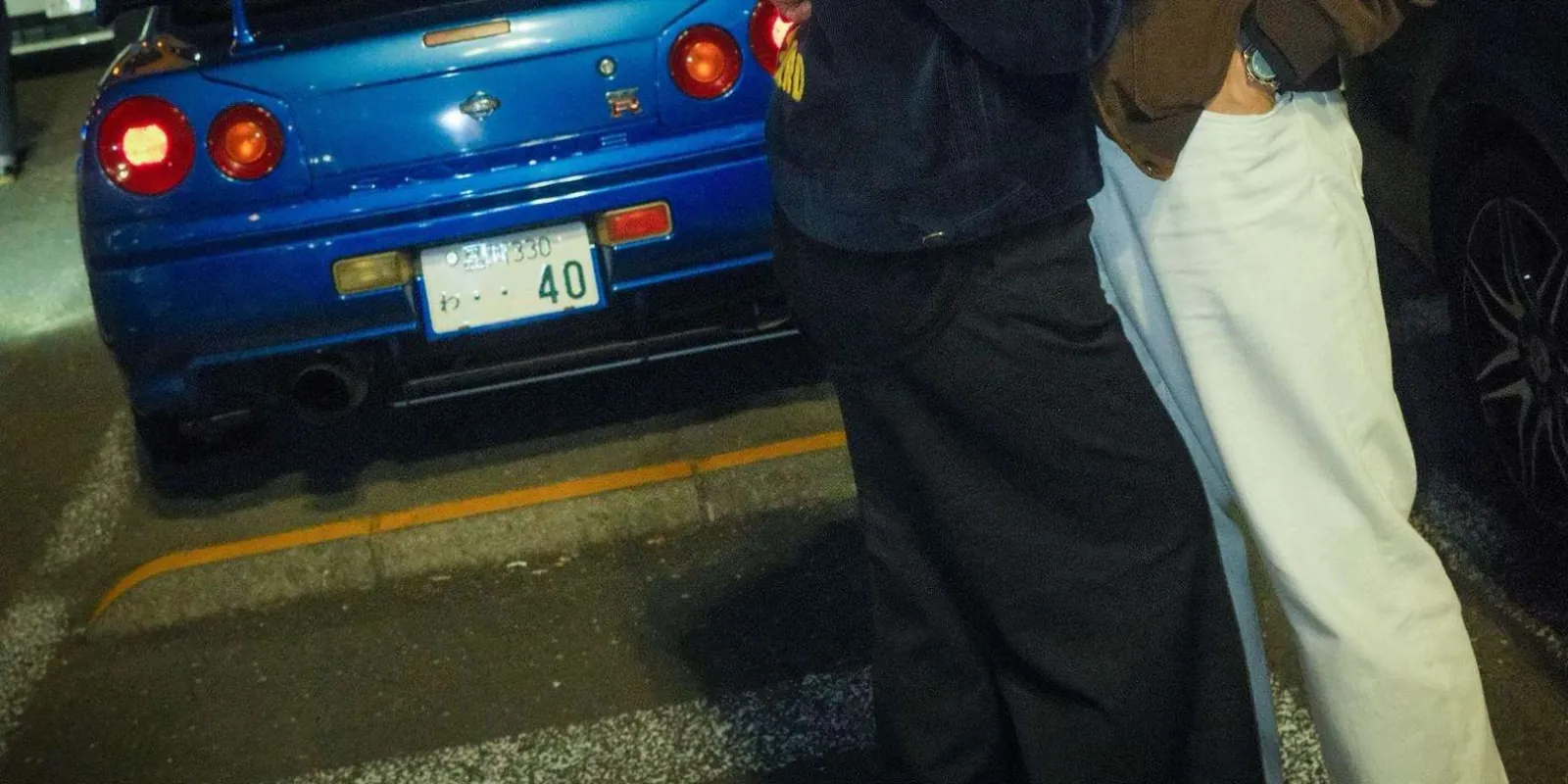 Close-up of a blue Nissan Skyline GT-R R34's taillights and Japanese number plate