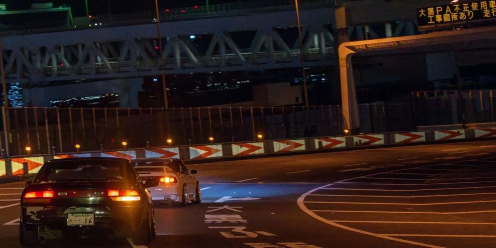White Nissan GT-R Nismo's rear three-quarter view among other GT-Rs at a night car meet